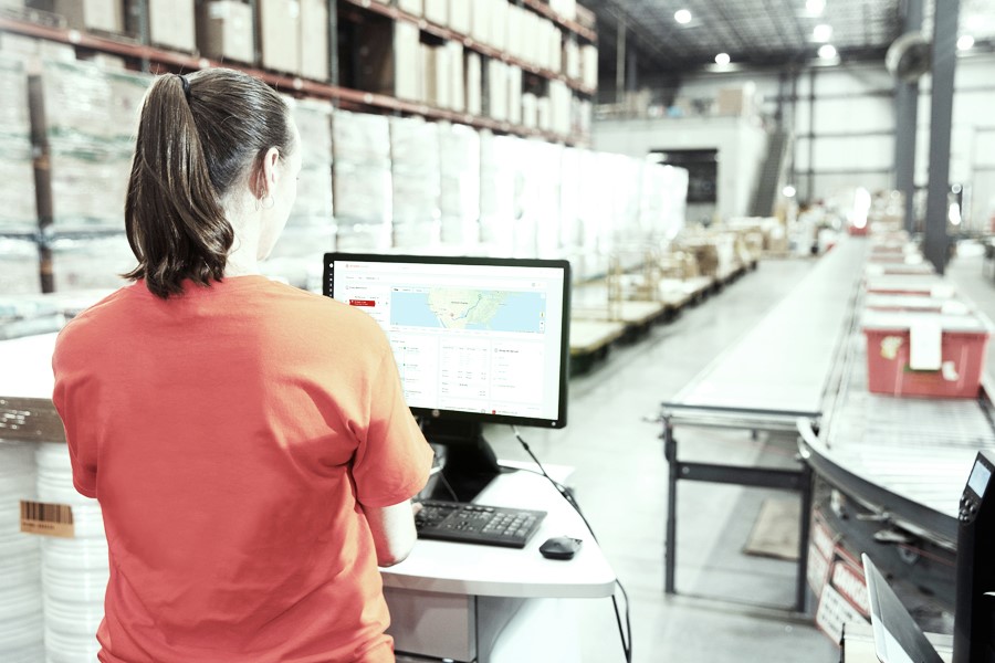 employee at warehouse in front of a pc